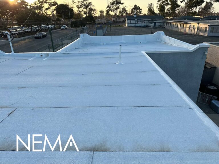 White flat roof coating on a building with parapet walls