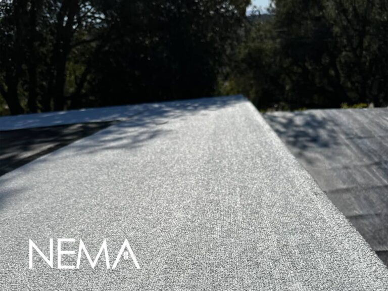 Granulated surface of a finished low-slope roof in the sun