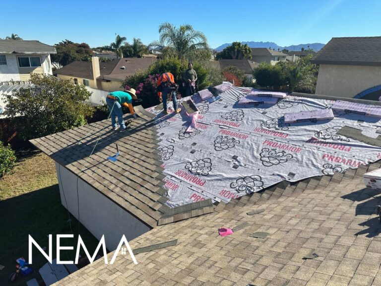 Roofing crew laying underlayment on a shingle roof