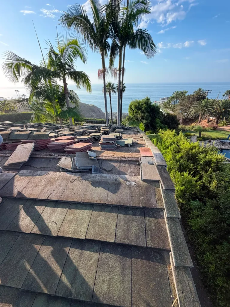 Tile roof tear-off on a coastal home, ocean in the background
